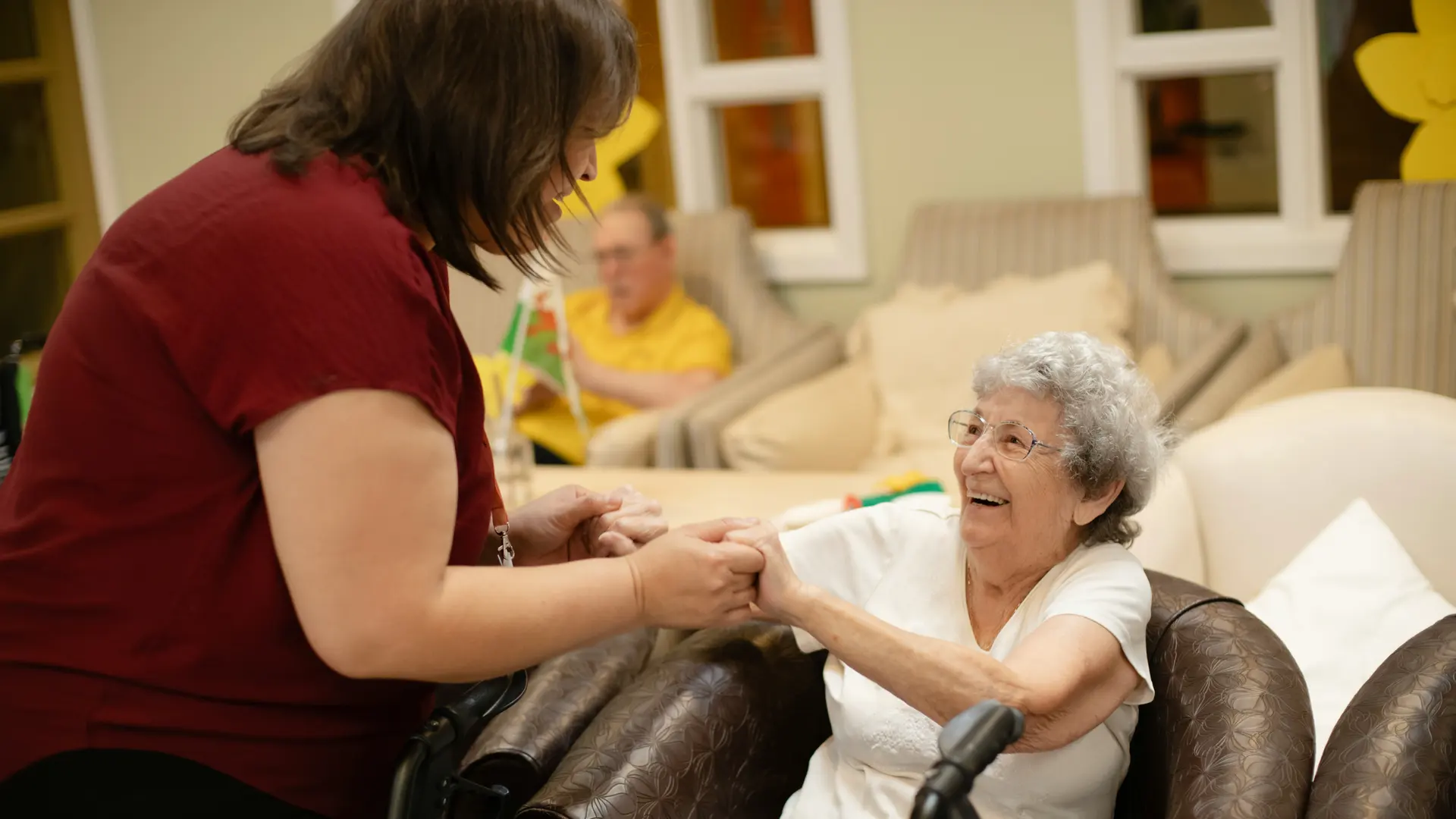 Caregiver holding hands with a smiling senior woman in Central Illinois